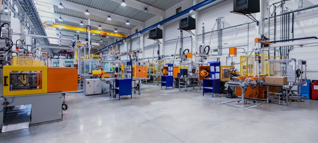 Horizontal image of huge new modern factory with robots and machines producing industrial plastic pieces and equipment. Wide angle view of futuristic machines standing on flooring and having the monopole of all work, taking the place of human work. There is not necessary use human hand. Wide angle, view, no people, space for copy.